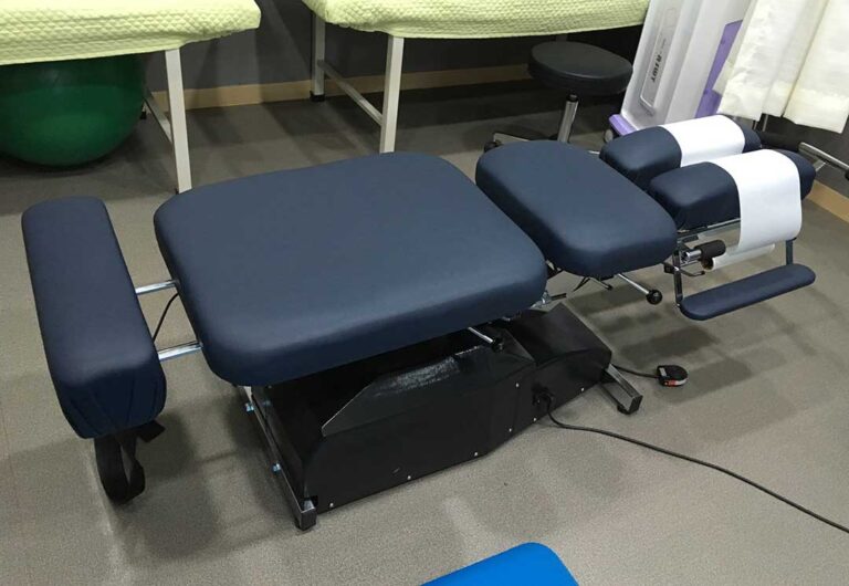 Person walking on an indoor floor while a clinician observes foot placement and lower-body alignment.